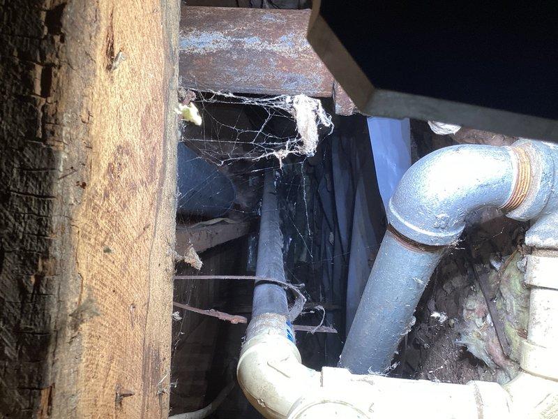 Responded to estimate request for removal of abandoned lavatory drain pipe protruding through floor in former bathroom location. Accessed piping from basement level through floor opening and cut off obsolete drain line and S-trap assembly below floor level. Cut remaining pipe stub flush with finished floor surface on upper level to eliminate tripping hazard and allow for proper floor refinishing. Removed debris and verified no active plumbing connections were affected during pipe removal process.
