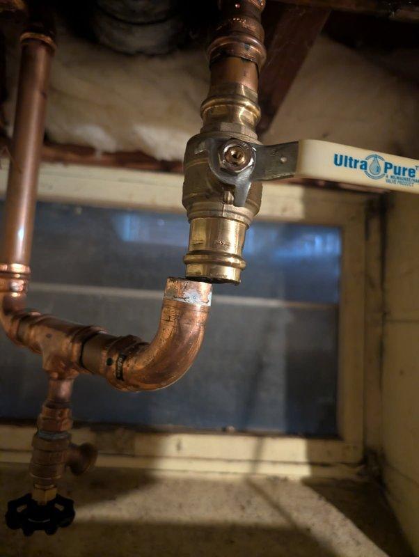 Responded to a burst pipe emergency where a ProPress fitting failed on the water supply line to the outdoor sprinkler system. Cut out the compromised section of copper piping and installed new pipe with proper fittings to restore water flow. Additionally, replaced temporary flexible supply lines to the water softener with permanent copper piping and shut-off valves, upgrading the installation to meet proper plumbing standards and eliminate the unreliable temporary connections.