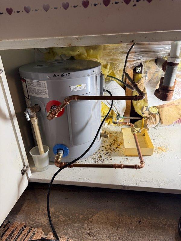 Responded to back cottage for leaking water heater supply valve. Upon inspection, discovered ball valve had developed a pinhole leak in the side of the valve body. Removed defective ball valve and old 90-degree elbow fitting by unsweating copper connections. Installed new press-fit 90-degree elbow and press-fit ball valve to eliminate leak and restore proper water supply control to tanked water heater unit. System tested and verified operational with no leaks present.
