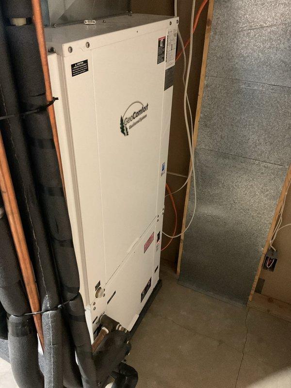 Responded to no cooling complaint on 16-year-old GeoComfort geothermal heat pump system affecting entire home. Upon inspection, discovered unit was completely out of refrigerant with no visible oil residue inside the cabinet, indicating a potential leak in the coaxial coil. Given the age of the system at approximately 16-18 years and the complete loss of refrigerant charge, recommended full system replacement rather than repair. Documented equipment condition with photos and scheduled follow-up consultation to discuss replacement options.