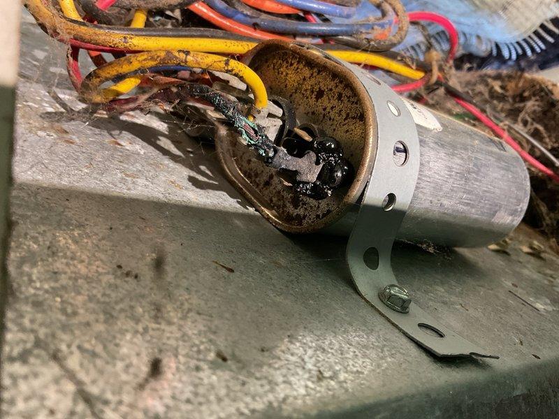 Responded to no cooling complaint on 20-year-old air conditioning system. Upon arrival, access to interior was restricted. External inspection of condensing unit revealed critical safety hazard: run winding wire to compressor was completely burned off. System showed evidence of recent capacitor replacement, however refrigerant charge was found to be very low. Given the burned wiring condition and fire risk, immediately pulled the electrical disconnect to prevent system operation until repairs could be completed. Documented equipment condition with photographs and provided repair estimates to homeowner for review. Unit remains inoperable pending approval of necessary electrical repairs and refrigerant system evaluation.