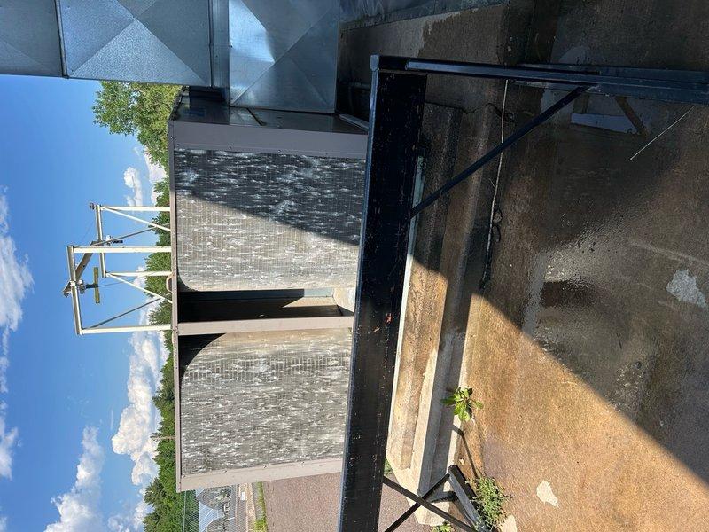 Responded to no cooling complaint on commercial showroom rooftop unit. Upon arrival, found system calling with blower operational but compressors failing to engage. Cycled power multiple times; compressors would run briefly before tripping on high pressure safety. Initially only one condenser fan motor would start during power cycles. Identified heavily fouled condenser coil as root cause of high pressure condition. Performed condenser coil cleaning, which restored proper airflow and system operation. Verified both compressors and condenser fans now operating correctly with normal pressures. Noted dirty air filters and worn fan belt requiring future replacement. System restored to full cooling capacity. Recommended comprehensive tune-up maintenance for this unit and secondary office RTU to prevent similar issues.