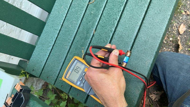 Responded to a no cooling complaint on a 2-year-old Lennox air conditioning system that was blowing hot air and had ceased operation the previous evening. Upon arrival, diagnosed the issue by testing the outdoor disconnect and discovered failed fuses—one reading 0.9 ohms and the other showing an open line (OL). Replaced the defective disconnect fuses, restoring power to the condenser unit and returning the system to normal cooling operation.
