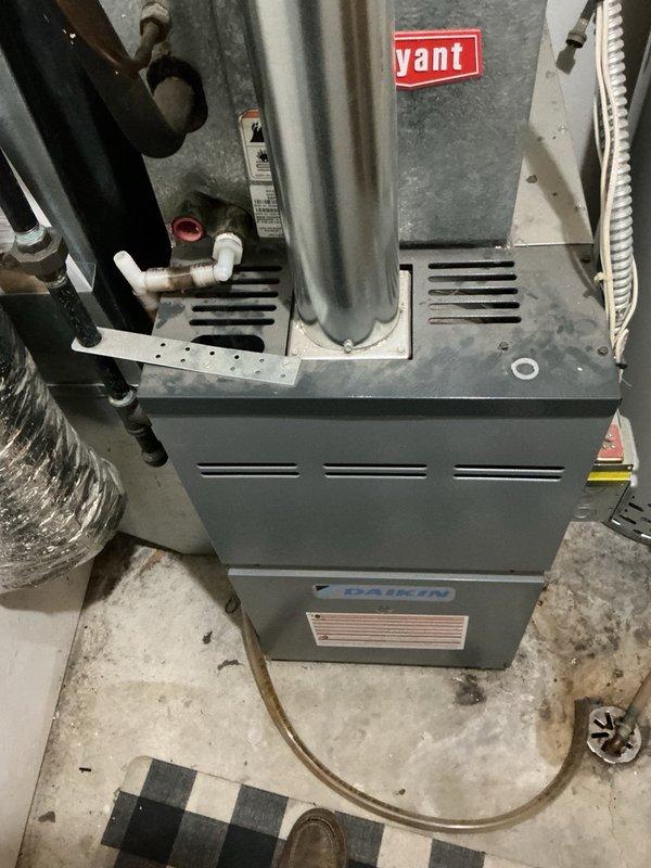 Responded to no cooling complaint on residential AC system with water leaking from furnace. Cleared plugged evaporator drain line that was causing overflow at top of furnace cabinet. Upon startup, diagnosed elevated head pressure at outdoor unit. Removed condenser top panel and extracted mouse nest from unit base, then pressure washed condenser coils to restore proper airflow. Reassembled unit and verified system operation with 20° temperature split across evaporator coil, confirming proper cooling performance restored.