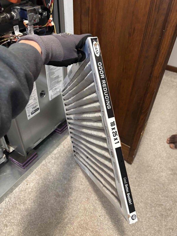 Responded to service call for loud noise occurring when air conditioning system shuts down at thermostat setpoint on recently installed three-month-old unit. Upon arrival, initiated cooling cycle at thermostat and observed excessive static pressure causing ductwork to collapse inward during operation and release with audible bang upon system shutdown. Identified heavily soiled 16x25x1 air filter as primary cause of restricted airflow and high static pressure. Replaced dirty filter with new odor-reducing pleated filter. Attempted to verify and adjust blower motor speed settings to reduce static pressure and noise levels, though exact CFM setting could not be determined from control board. Temporarily reduced blower speed which successfully eliminated ductwork noise but resulted in decreased airflow volume. Consulted with homeowner regarding trade-off between noise reduction and cooling performance. Homeowner elected to restore original factory blower speed setting to maintain maximum ai