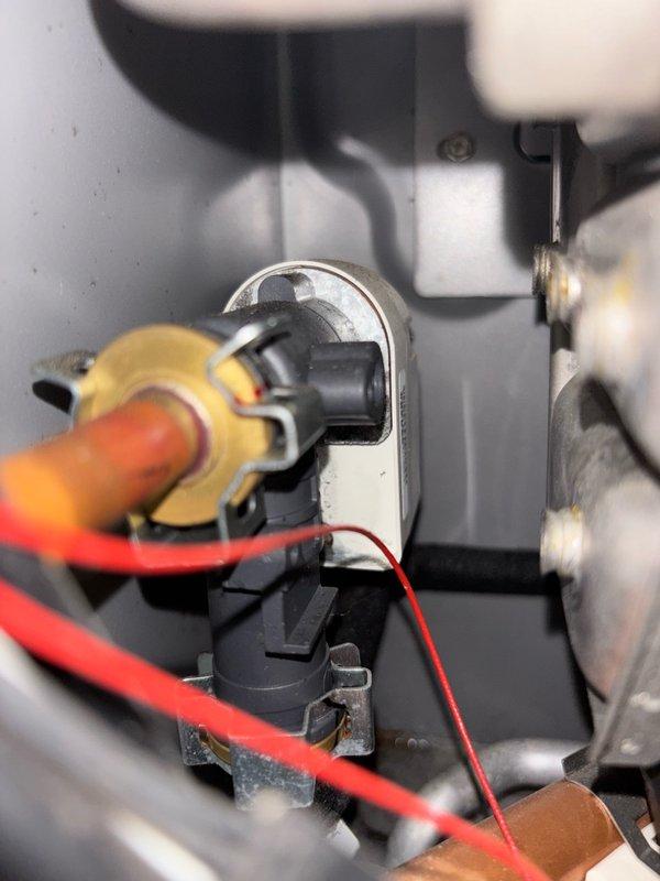 Responded to service call for leaking tankless water heater that was tripping GFCI outlet. Located unit in utility room and confirmed Westinghouse tankless water heater model with visible water leak. Performed visual inspection and identified slow drip originating from internal solenoid valve positioned directly above inlet gas line. Conducted electrical testing to verify GFCI tripping issue and confirmed correlation with internal leak condition. Documented leak location and captured photographic evidence of affected solenoid component and electrical connections. Contacted Westinghouse technical support line to initiate warranty case and obtain manufacturer guidance for solenoid replacement procedure. Received case initiation instructions via email from manufacturer support team. Job paused pending manufacturer response and parts availability determination, as internal component replacement requires factory authorization and specific replacement procedures for this tankless unit model.