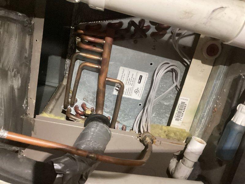 Responded to no cooling complaint on air conditioning system blowing warm air and experiencing freeze-up. Inspected evaporator coil for blockage and verified clear. Tested system pressures and operation, identifying low refrigerant charge on R-410A system. Presented repair options including worst-case scenario estimate. Per customer authorization, added one pound of R-410A refrigerant with dye tracer to system. Verified proper operation after refrigerant charge. Advised customer this is a temporary repair due to suspected leak and may require future service. Customer declined equipment replacement at this time. Unable to obtain unit specifications due to illegible data tag.