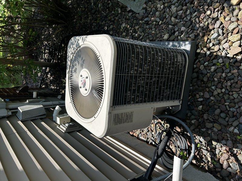 Responded to no cooling complaint on 20+ year old R22 system experiencing coil freeze-up. Customer had unit off with fan running to allow thawing. Performed diagnostic inspection of blower assembly, air filter, and evaporator coils—all found clean with adequate airflow. Blower capacitor tested slightly below optimal rating but sufficient for full-speed operation. Connected manifold gauges to refrigerant circuit and identified low refrigerant charge as primary cause of freeze condition. Due to system age, R22 refrigerant type, and declining charge indicating potential leak, recommended customer consult with service advisor regarding repair versus replacement options given the obsolete refrigerant and system longevity considerations.