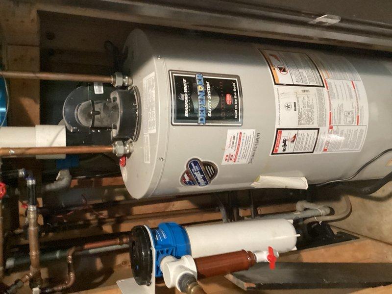 Responded to urgent water leak and flooding situation caused by pinhole leak in well line entering the residence. Upon arrival, confirmed water had been shut off at main but leak persisted from compromised pipe behind water heater. Inspected copper piping system, water heater connections, and filtration components to isolate source of active leak. Identified pinhole failure in well supply line requiring specialized well contractor for permanent pipe replacement and recommended immediate contact with well service provider to complete repair.