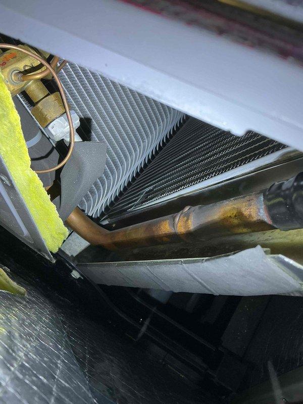 Responded to no cooling call on residential HVAC system over 10 years old with reported water leak in basement. Upon inspection, diagnosed low refrigerant charge and severely plugged evaporator coil restricting airflow and cooling capacity. Added refrigerant to proper operating levels and thoroughly cleaned coil to restore heat transfer efficiency. System tested and confirmed returning to normal cooling operation with proper temperature differential.