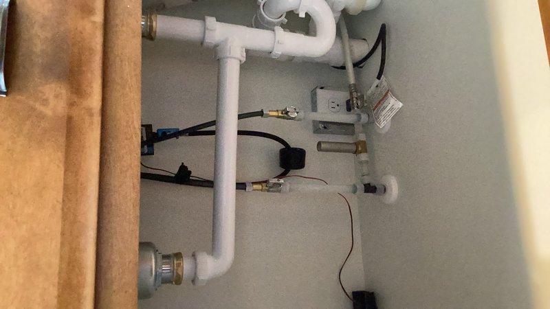 Completed kitchen plumbing hookup including installation of new faucet on double-basin stainless steel sink. Connected water supply lines, installed drain assembly with P-trap configuration, and verified proper operation of all fixtures. All connections tested and confirmed leak-free with full functionality restored.