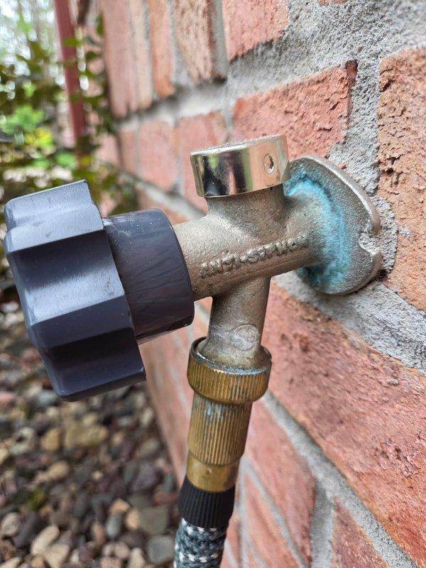 Responded to service call for dripping exterior hose bib mounted on brick wall. Upon inspection, identified failed Mansfield brand anti-siphon frost-free spigot with turquoise corrosion visible on valve body. Customer had previously attempted washer replacement without success. Diagnosed faulty internal stem assembly requiring replacement. Ordered manufacturer-specific stem parts for proper repair of this 1999-era installation.