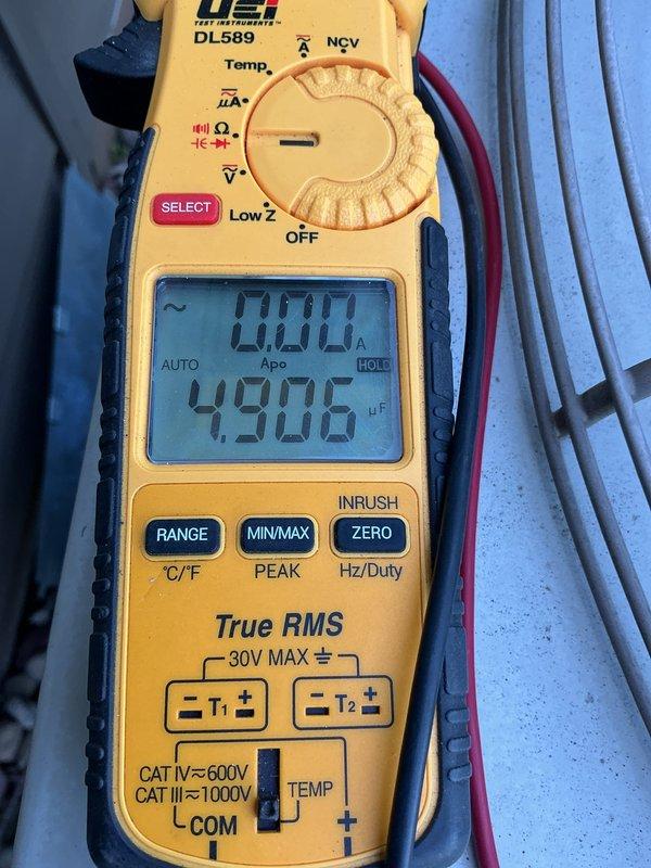Responded to no-cool call on 26-year-old residential HVAC system with non-operational condenser unit. Upon inspection, found condenser fan motor seized, contactor heavily pitted with visible arcing damage, and condenser coil contaminated from animal urine exposure. Tested capacitor with multimeter, reading 4.906 μF, which was within acceptable range. Diagnosed primary failures as seized condenser fan motor and failed contactor preventing compressor operation. Recommended comfort advisor consultation for condenser fan motor and contactor replacement due to age of system and extent of component degradation.