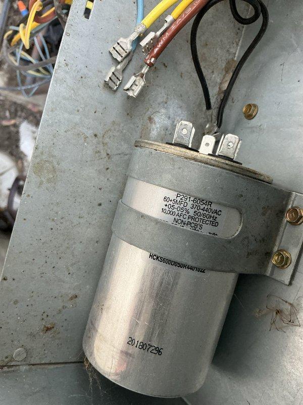 Responded to no-cool call on 26-year-old residential HVAC system with non-operational condenser unit. Upon inspection, found condenser fan motor seized, contactor heavily pitted with visible arcing damage, and condenser coil contaminated from animal urine exposure. Tested capacitor with multimeter, reading 4.906 μF, which was within acceptable range. Diagnosed primary failures as seized condenser fan motor and failed contactor preventing compressor operation. Recommended comfort advisor consultation for condenser fan motor and contactor replacement due to age of system and extent of component degradation.