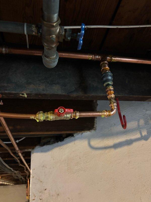 Responded to return visit for tankless water heaters experiencing recurring beeping errors due to insufficient gas pressure. Relocated the soft copper gas supply line from the low-pressure side to the high-pressure side of the main gas regulator to resolve pressure issues affecting both units. Capped the original gas connection point, installed a tee fitting with appropriate connectors, and rerouted the gas line to stub into the high-pressure side of the regulator. Pressurized the system and performed a 15-minute leak test on all new connections with negative results. Bled air from the gas lines, relit pilot lights on both tankless units, and verified proper operation before completing the work.