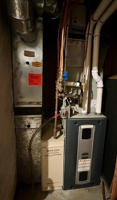 Responded to no cooling complaint on 9-year-old residential air conditioning system. Upon arrival, found evaporator coil frozen and blower motor not operating. Tested voltage at motor and confirmed power supply was adequate. Discovered loose electrical connection at blower motor plug; reconnected plug and motor began operating normally. Unable to assess refrigerant charge due to frozen coil condition. Instructed customer to turn system off, run furnace heat briefly to accelerate defrost, then operate fan only to complete coil thawing process before resuming cooling operation the following day. Advised customer to contact for follow-up service if issues persist after coil has fully thawed and system resumes normal operation.