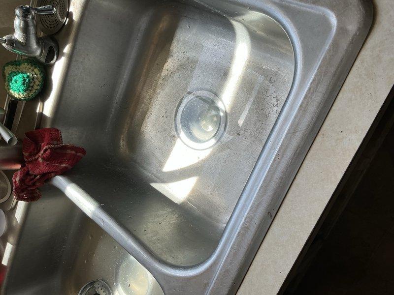 Kitchen sink drain was completely blocked with heavy grease buildup beyond the trap. Ran drain machine through the line approximately seven times to break through the solid obstruction and restore proper drainage. Flow successfully re-established.