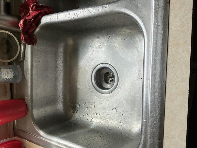 Kitchen sink drain was completely blocked with heavy grease buildup beyond the trap. Ran drain machine through the line approximately seven times to break through the solid obstruction and restore proper drainage. Flow successfully re-established.