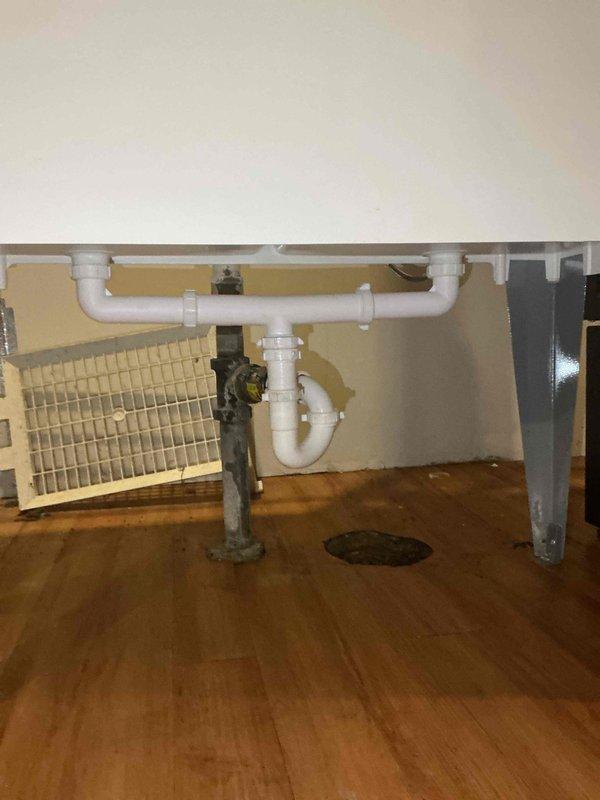 Installed a new white dual-compartment laundry tub with a two-handle faucet assembly, connecting to existing water supply lines and drain infrastructure. The installation included mounting the utility sink, connecting brass shut-off valves, attaching supply hoses to the faucet, and verifying proper drainage through the existing PVC P-trap assembly. All connections were tested and confirmed leak-free upon completion.
