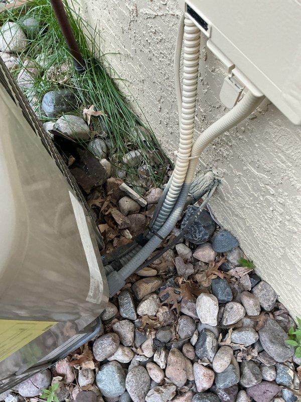Responded to no cooling call on 12-year-old Goodman air conditioning system. Diagnosed outdoor condenser unit not receiving 24-volt power supply from indoor unit. Upon inspection, discovered control wiring had been cut, likely during recent basement renovation that included finished ceiling installation and thermostat relocation. Recommended customer contact licensed electrician to run new low-voltage control wire from air handler to condenser unit to restore system operation.