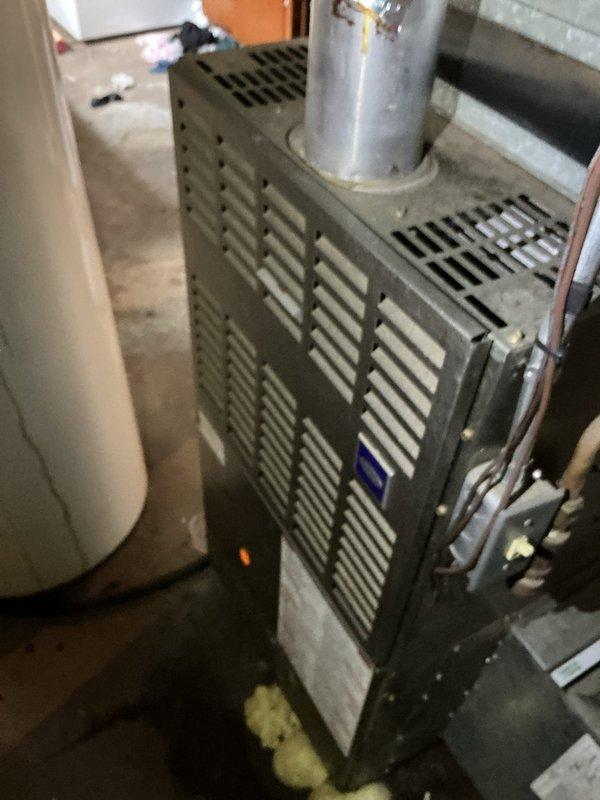Responded to service call for HVAC unit 12-4 experiencing excessive noise and inadequate cooling. Upon inspection, found system completely frozen with R410A refrigerant present. Conducted thorough examination of furnace and discovered cracked heat exchanger, presenting a safety hazard. Tagged furnace as unsafe for operation per industry safety protocols. Documented equipment condition with photographs showing furnace cabinet, refrigerant lines, and overall installation in utility area. Advised customer that repairs are not feasible due to severity of heat exchanger damage and recommended full system replacement.