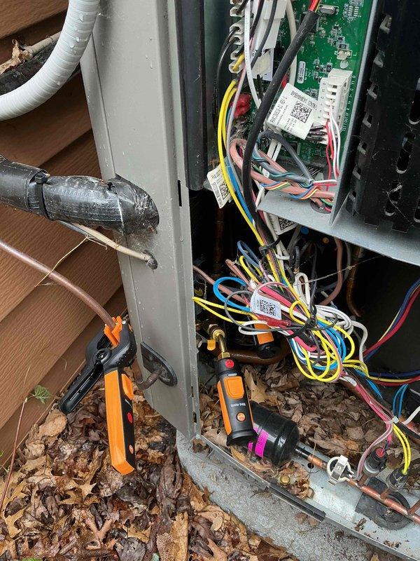 Responded to no cooling call on 1-2 year old Lennox heat pump system. Upon arrival, performed diagnostic inspection and found low refrigerant levels. System was operational but running with reduced cooling capacity. Checked refrigerant charge and identified deficiency requiring attention. Inspected indoor air handler unit and outdoor condenser components, documenting system condition with photos of control panel wiring and indoor equipment. Advised customer on proper air filter maintenance schedule due to presence of multiple pets in home, as inadequate filtration can lead to reduced airflow and system efficiency issues.