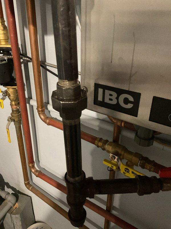 Responded to gas leak detected by LP supplier at boiler fitting in basement. Upon inspection, discovered union connection and multiple gas piping fittings were inadequately tightened from original installation approximately three years prior. Applied pipe dope and properly torqued all gas line connections including unions, valves, and fittings on the IBC boiler system. Verified all connections were secure and gas-tight. System supplies radiant floor heating to basement area, with LP supplier having shut off valve to affected line as precautionary measure prior to arrival.