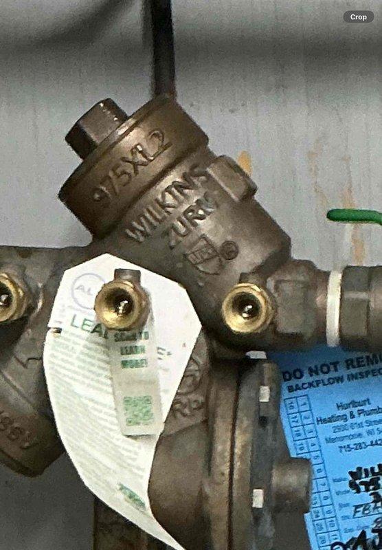 Responded to water leak at RPZ backflow preventer assembly located in parlor near chemical room. Upon inspection, identified active leak at Wilkins backflow prevention device and determined Y strainer requires replacement due to failure. Documented existing conditions showing corrosion on green supply pipe, aged brass valve assembly with compliance tags intact, and multiple ball valves in system. Ordered necessary replacement parts for Y strainer to complete repair and restore proper operation of backflow prevention system.