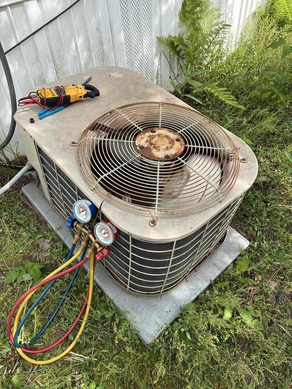 Responded to no cooling call on 10+ year old R22 system. Found condenser operating with restricted airflow due to partially plugged coil and significantly low refrigerant pressures (suction 10-15 PSI, discharge 150 PSI), indicating system leak. Verified indoor blower operation and confirmed air filters in acceptable condition. Explained to homeowner that unit requires leak repair and R22 recharge, but due to age of equipment and refrigerant costs, replacement would be more cost-effective. Customer agreed to have comfort advisor provide replacement estimates.