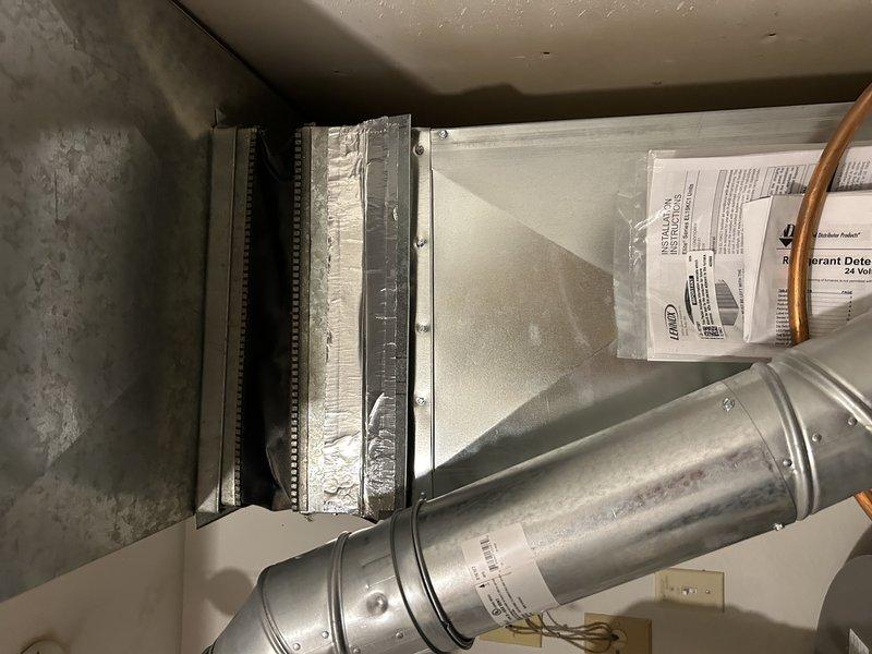 Responded to warranty callback for loud thunking noise occurring at system startup on recently installed air conditioning system. Diagnosed source of noise as ductwork popping at filter slot location above evaporator coil where modifications were made during initial installation. Secured ductwork by installing additional screws and adding slip connector section to reinforce and stabilize the affected area, eliminating the noise issue. System tested and verified operating properly with no further abnormal sounds detected.