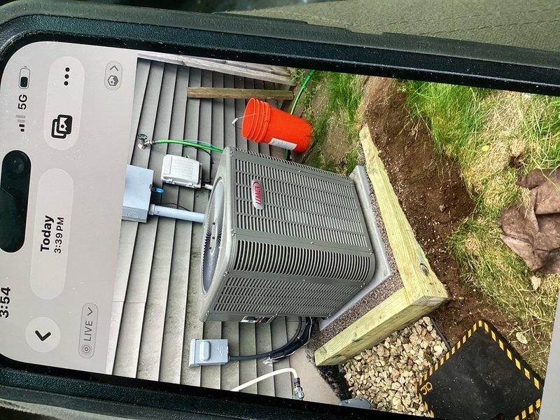 Completed warranty repair on outdoor condensing unit experiencing instability due to steep grade erosion. Excavated and installed two rows of pressure-treated timber retaining wall to prevent equipment from sliding down slope. Unit was repositioned on gravel pad with proper drainage and structural support to ensure long-term stability and code compliance.