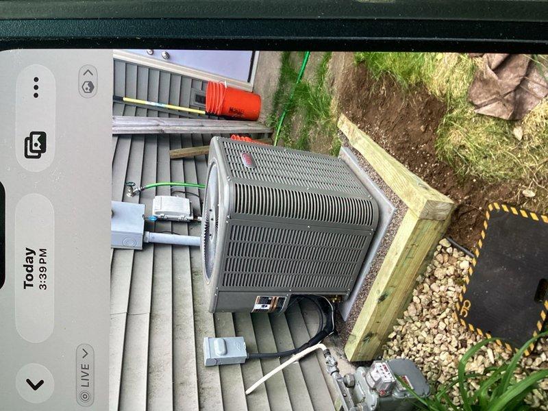 Completed warranty repair on outdoor condensing unit experiencing instability due to steep grade erosion. Excavated and installed two rows of pressure-treated timber retaining wall to prevent equipment from sliding down slope. Unit was repositioned on gravel pad with proper drainage and structural support to ensure long-term stability and code compliance.