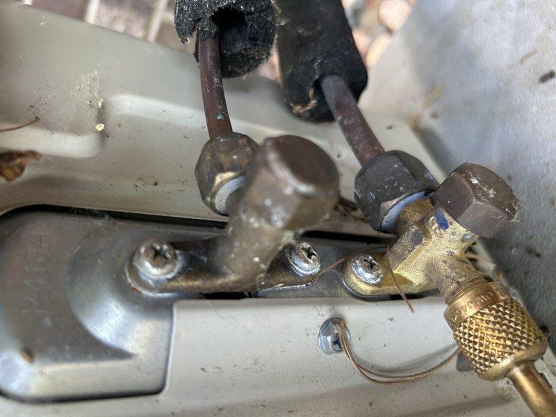 Responded to no cooling complaint on 15-16 year old Daikin mini split system in bedroom. Upon inspection, found heavily soiled blower wheel in indoor head unit causing restricted and inconsistent airflow. Connected manifold gauges and observed approximately 18 psi on suction side, indicating low refrigerant charge even accounting for reduced airflow from dirty blower wheel. Evaporator coil showed dust and residue accumulation, and refrigerant line connections displayed age-related corrosion and oxidation consistent with system age. Advised customer that blower wheel cleaning must be performed prior to accurate refrigerant charge assessment. Provided repair options including complete mini split head cleaning, refrigerant recovery and recharge to proper specifications by weight, and UV dye injection for leak detection. Coordinated service advisor visit for replacement system evaluation due to unit being out of warranty and age-related deterioration of components.