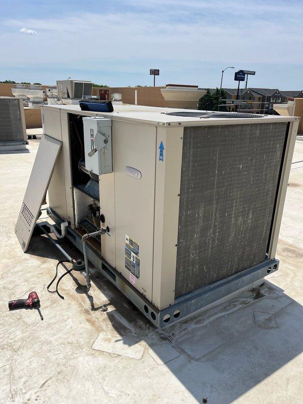 Responded to no cool call on commercial rooftop unit with no airflow into building. Upon inspection, found blower motor running but blower belt had completely failed and separated, preventing blower wheel operation. Installed spare belt found in unit compartment to restore immediate cooling operation. Observed condenser coil appears partially restricted and recommended follow-up service including new blower belt replacement, air filter change, and condenser coil cleaning to ensure optimal system performance and prevent future failures.