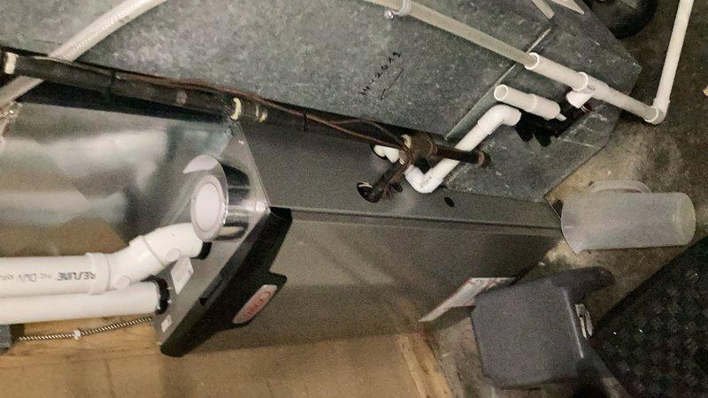 Responded to water quality issue related to fish odor in residential water supply. Placed acid neutralizer system into bypass mode to eliminate odor problem. System had been actively treating water but was identified as the source of the undesirable smell. Documented equipment configuration including water heater, expansion tank, and water treatment components in mechanical room.
