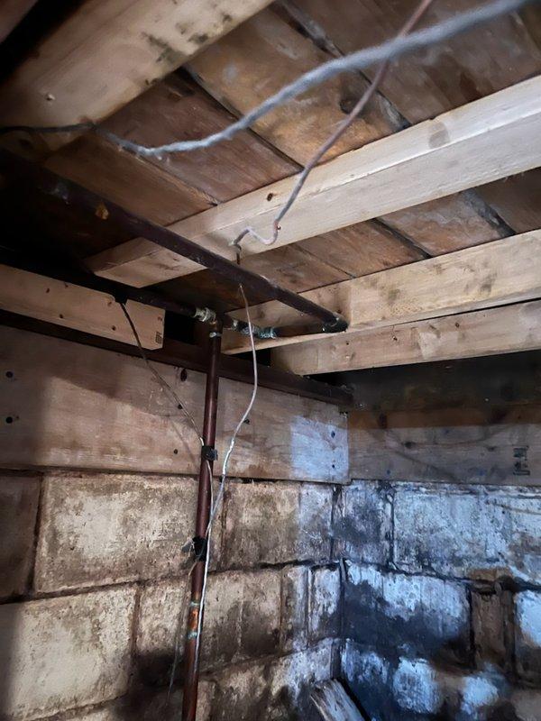 Responded to a slow dripping leak at a copper pipe elbow in the well room that had been occurring for several days. Upon inspection, identified a failed sweat joint at a 90-degree elbow showing extensive corrosion and verdigris buildup. Replaced the compromised house ball valve and repaired piping from the valve up through the tee connection, installing new copper lines to eliminate the leak and ensure proper water flow to the residence.