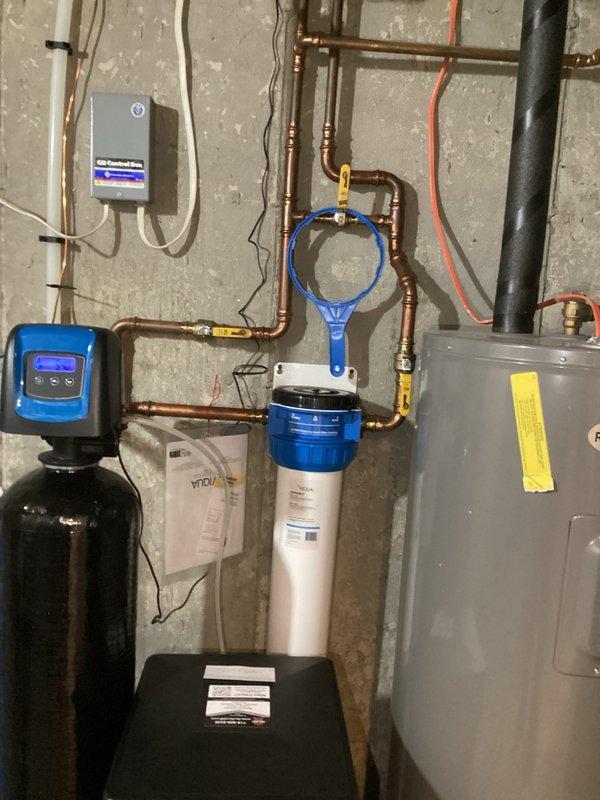 Completed comprehensive plumbing inspection of residential property, identifying several items requiring attention during next service visit. Thoroughly evaluated water filtration system, including water softener with digital control head and white filter housing with replaceable cartridge. Determined that water filter replacement is necessary and provided detailed explanation of filtration system operation and maintenance requirements. Inspected bathroom fixtures including sink, faucet, and drain assembly. Documented all findings with photographs of plumbing equipment and fixtures for service records. Advised homeowner of identified deficiencies noted in inspection report to be addressed during subsequent appointment.