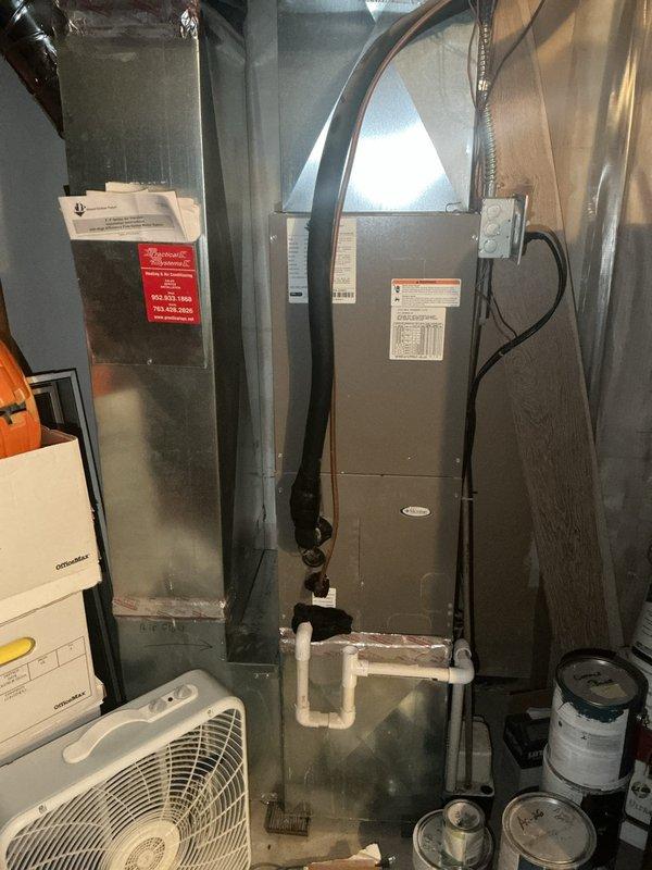 Responded to no cooling complaint on main floor air conditioning system. Upon inspection, found system operating with low refrigerant charge of obsolete refrigerant type, resulting in evaporator coil freeze-up and restricted airflow at basement-located air handler. Documented system age exceeding 10 years and obsolete refrigerant requiring specialized handling. Explained to customer that refrigerant is no longer readily available and system condition warrants replacement rather than repair. Photographed existing air handler and mechanical room equipment for documentation purposes. Scheduled replacement estimate appointment for new air conditioning system and air handler installation.