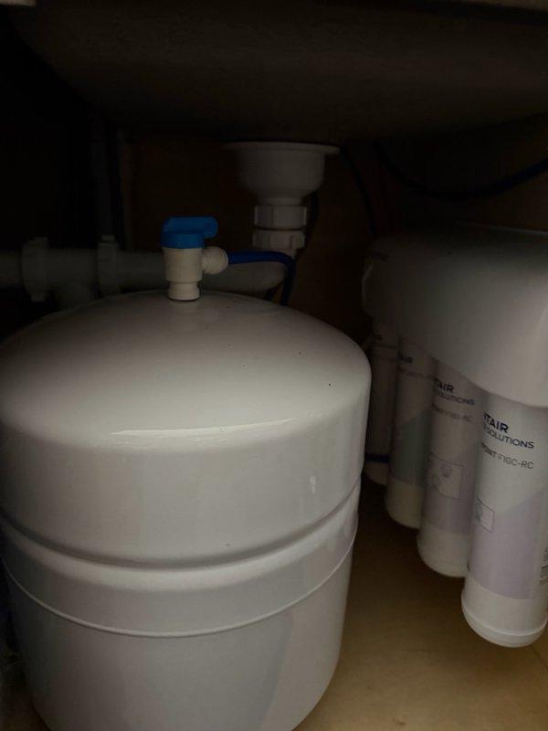 Responded to service call for reverse osmosis system producing excessive noise after use. Upon inspection, identified air gap hissing loudly for approximately 10 minutes following water dispensing from RO unit. Diagnosed issue as improper drainage causing air gap overflow and noise disturbance. Installed check valve on RO drain line to prevent backflow and eliminate hissing sound from air gap. Tested system operation and verified noise issue resolved. System now functioning properly with normal quiet operation after water use.