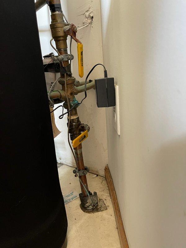 Responded to water leak at main meter assembly. Upon inspection, identified active leak at meter horn connection with deteriorated gasket. Multiple valves in the assembly showed significant corrosion and rust buildup, indicating age and exposure to moisture. Replaced failed gasket at meter horn to resolve leak. Documented condition of corroded brass fittings and yellow-handled shut-off valves throughout vertical pipe assembly for future maintenance reference.