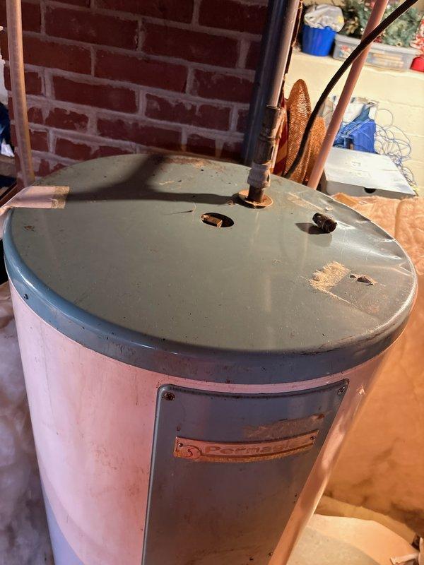 Replaced a 30 year-old 50-gallon Permaglas electric water heater with a new 50-gallon Bradford White electric water heater with 10-year warranty. The removal required two technicians due to basement location and unit weight. Successfully disconnected existing electrical and plumbing connections, removed the deteriorated unit showing significant rust and wear at the base, and installed the new water heater with proper copper piping connections and electrical hookup to manufacturer specifications.