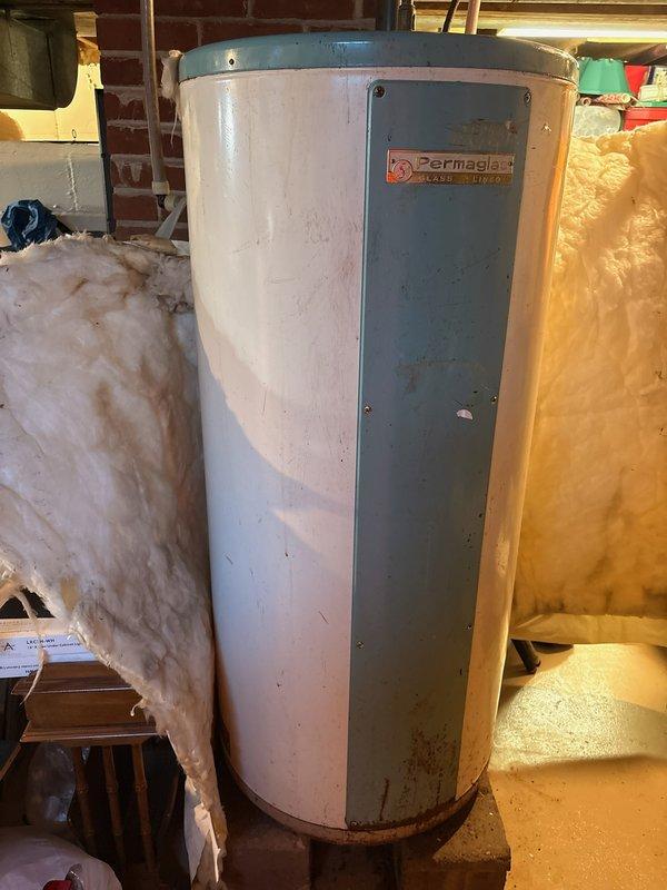 Replaced a 30 year-old 50-gallon Permaglas electric water heater with a new 50-gallon Bradford White electric water heater with 10-year warranty. The removal required two technicians due to basement location and unit weight. Successfully disconnected existing electrical and plumbing connections, removed the deteriorated unit showing significant rust and wear at the base, and installed the new water heater with proper copper piping connections and electrical hookup to manufacturer specifications.