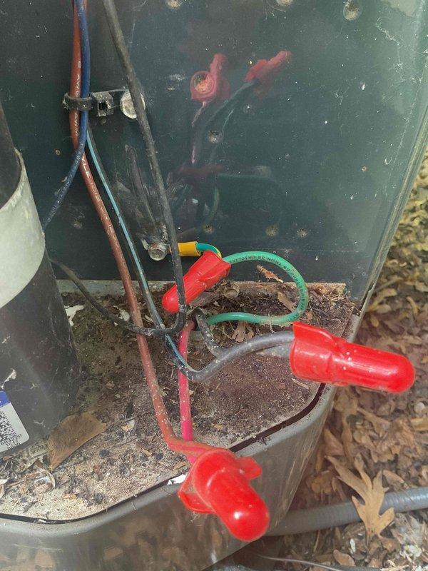 # No Cool Call - Outdoor Unit Inoperative

Responded to no cooling complaint on 10+ year old air conditioning system. Upon arrival, found indoor blower fan running continuously but outdoor condensing unit completely inoperative. Previous service history indicated compressor replacement performed last month. 

Visual inspection revealed high voltage wiring damage at outdoor unit caused by rodent activity. Wiring insulation had been chewed through, compromising electrical connections and preventing power delivery to the condensing unit. Found multiple damaged conductors and deteriorated wire connections with debris accumulation in electrical compartment.

Repaired damaged high voltage wiring by cutting back compromised sections and installing new wire connections with proper wire nuts. Re-routed and secured all electrical conductors to prevent future rodent access. Cleaned debris from electrical compartment including leaves and organic material that had accumulated around wire connection
