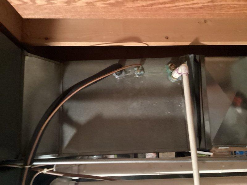 Responded to no cooling complaint on 30+ year old Heil central air conditioning system (Model CA5024vkb1) that was experiencing line freeze-up. Diagnosed faulty contactor that remained closed even when 24V power was disconnected, causing compressor to run continuously and resulting in system freeze-up. Verified evaporator coil was clear of obstructions and inspected all system components. Checked R-22 refrigerant pressures which were within acceptable range, confirmed approximately 20° temperature drop across system, and verified proper operation after addressing contactor issue. Unit returned to normal operation with adequate cooling performance despite age of equipment.