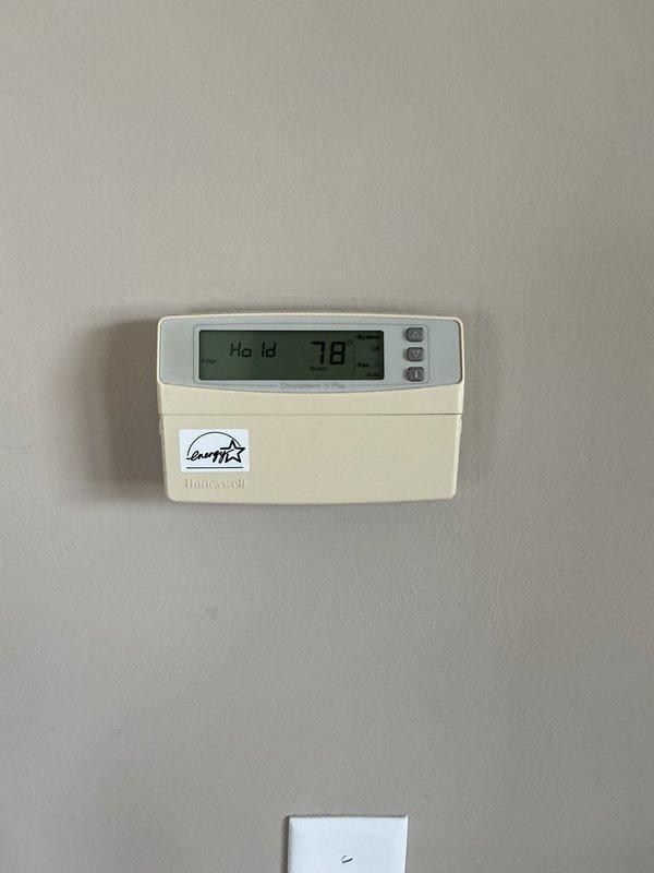 Responded to scheduled AC tune-up for 22-year-old R22 system. Upon arrival, discovered unit frozen solid with ice accumulation on both the evaporator coil and refrigerant line set. System was not operating properly despite initial customer indication that it was working. Documented frozen conditions with photographs showing ice buildup on exterior line set and current thermostat settings displaying 78°F on hold mode. Due to extent of freezing and age of R22 system, recommended comfort advisor consultation to assess underlying cause of freeze-up and discuss repair versus replacement options given the system's age and obsolete refrigerant type.
