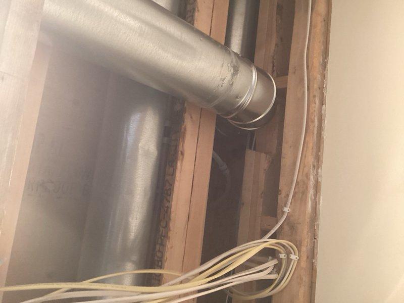 Responded to water leak originating from refrigerator water supply line located in drop ceiling area. Upon investigation, accessed the concealed PEX piping system between floor joists and identified a failed PEX tee fitting as the source of the active leak. Evidence of water damage and moisture staining was visible on surrounding wooden structural members. Isolated the water supply, removed the defective PEX tee fitting, and installed a new PEX tee connection using proper crimping techniques to restore water supply to the refrigerator. Verified all connections for proper seal and tested system under full pressure to confirm leak was eliminated and water flow was restored to normal operation.