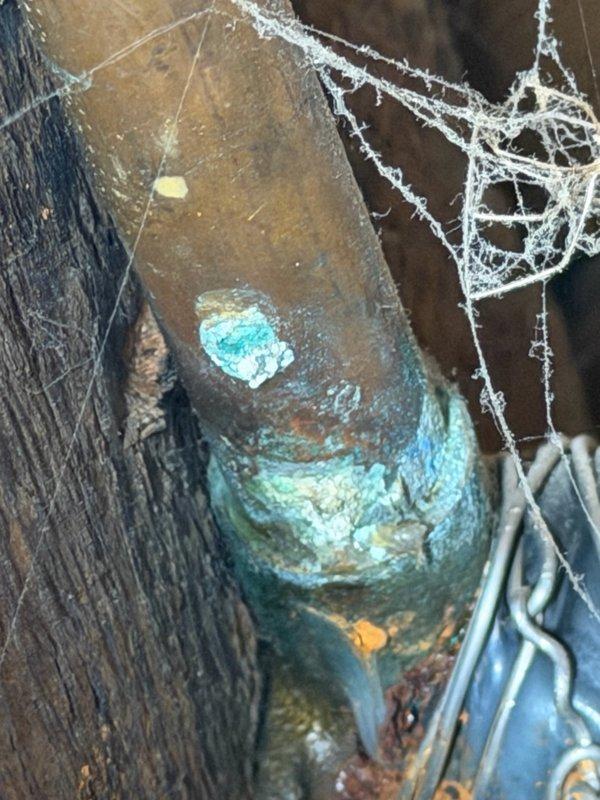 Completed comprehensive plumbing inspection as part of family rewards program. Accessed attic and crawlspace areas to assess plumbing system condition, documenting copper supply lines with visible oxidation and verdigris patina formation. Identified advanced corrosion on metal pipe fittings in crawlspace, with heavy blue-green copper corrosion indicating potential moisture exposure and age-related deterioration requiring monitoring or future replacement consideration.