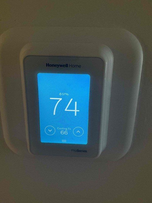 Responded to no cooling complaint on Mitsubishi 3.5-ton Intelliheat heat pump system with air handler and mini-split head. System was running continuously but unable to reach setpoint temperature at thermostat, while mini-split head connected to same outdoor condenser operated normally. Diagnosed communication fault between air handler control board and thermostat preventing proper system operation. Performed power cycle reset procedure on both furnace control board and Honeywell ProSeries thermostat to restore communication protocol. Verified thermostat display showed proper cooling mode and setpoint, confirmed system response to temperature adjustments, and restored normal cooling operation to air handler zone.
