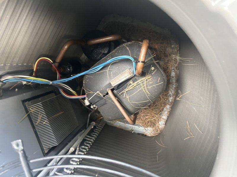 Completed annual air conditioning maintenance on 3-ton system per maintenance agreement. Tested unit operation and confirmed proper airflow with 20° temperature differential across coil. Verified air filter condition, cleared condensate drain line, and pressure-washed outdoor condenser coil. Inspected all electrical connections and mechanical components. Discovered significant accumulation of animal nesting material (straw/grass debris) around blower motor assembly and refrigerant lines inside air handler cabinet. System operating within normal parameters upon completion of service.