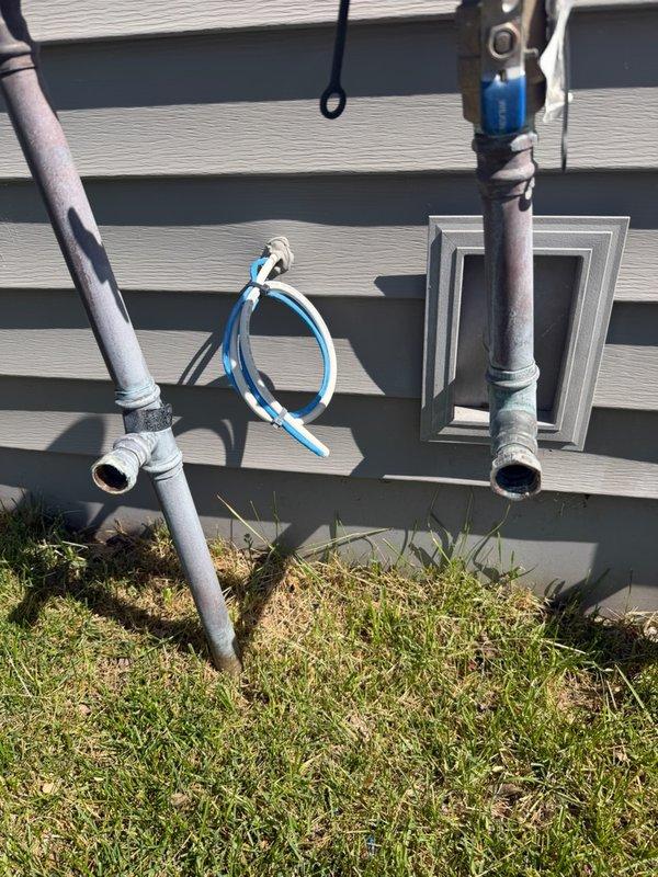 Responded to exterior sprinkler system leak at residential property. Upon inspection, identified failed pressure vacuum breaker (PVB) with cracked drain down port inside the fitting, causing visible water discharge. Removed compromised section of irrigation piping and installed replacement pipe segment. Installed drain down plugs to properly seal the irrigation system and prevent future leakage. System tested and confirmed operational with no active leaks following repair completion.
